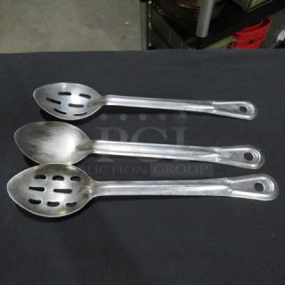 Set of three stainless steel serving spoons, including slotted and solid designs; used condition.