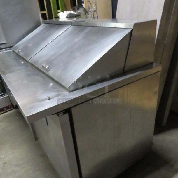 True TSSU-60-24M refrigerated prep table, two doors, includes one rack, on casters, stainless steel, 60x34x44 inches.