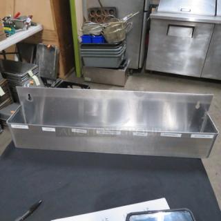 Stainless steel bottle rail, 24x4x6, in good condition, features labeled sections for organizing spirits or condiments.