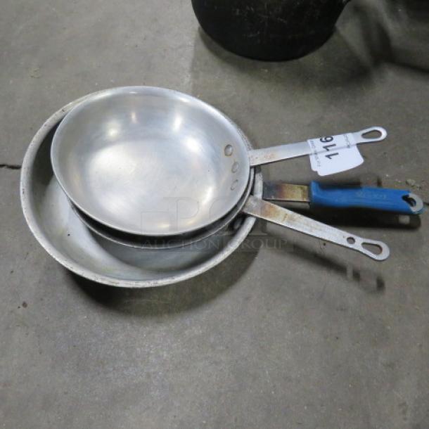 Three stacked sauté pans, assorted sizes, with visible wear. Blue handle on one and paper tag labeled "716."
