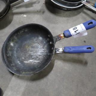 Assorted sauté pan with blue handles, well-worn interior, auction tag labeled "18."
