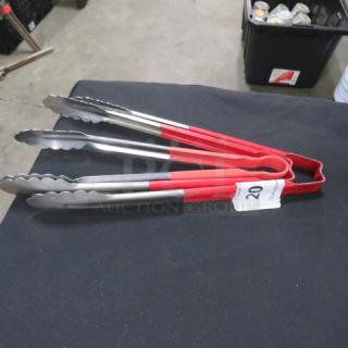 Red-handled stainless steel tongs on a table, item number 20, in good condition.