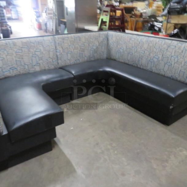 C-shaped booth with black cushioned seat and patterned backrest. Good condition, suitable for dining spaces or lounges.