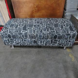 Contemporary cushioned waiting bench, 48x21x19 inches, geometric black and white upholstery, metal legs, in good condition.