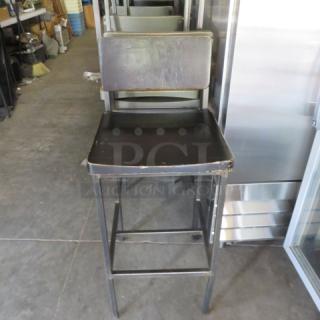 Metal bar height chair with wooden seat and back, featuring a footrest. Visible wear on edges. Ideal for rustic decor.