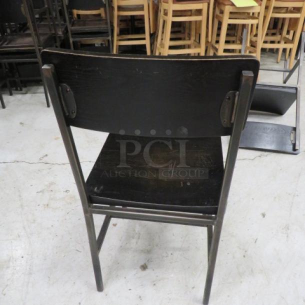 Black metal chair with wooden seat and back, model 4XBID. Shows minor wear, sturdy condition. Ideal for modern decor.
