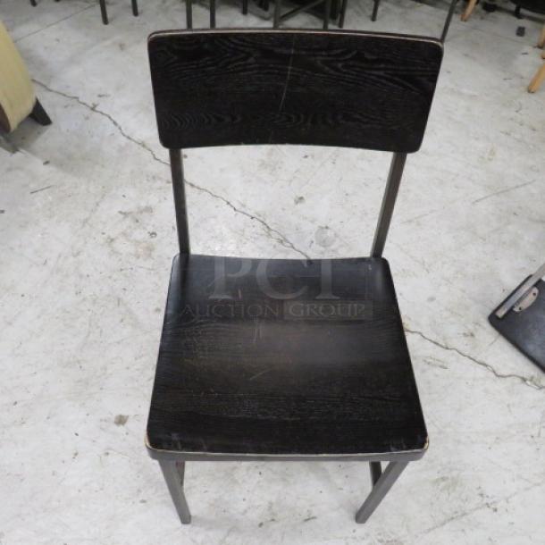 Black metal chair with wooden seat and back, model 4XBID, showing light wear, suitable for home or office use.