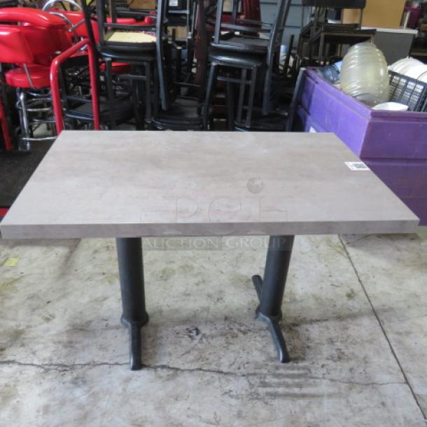 Gray table top on dual black pedestal bases, dimensions 48x30x30 inches. Simple, modern design in good condition.
