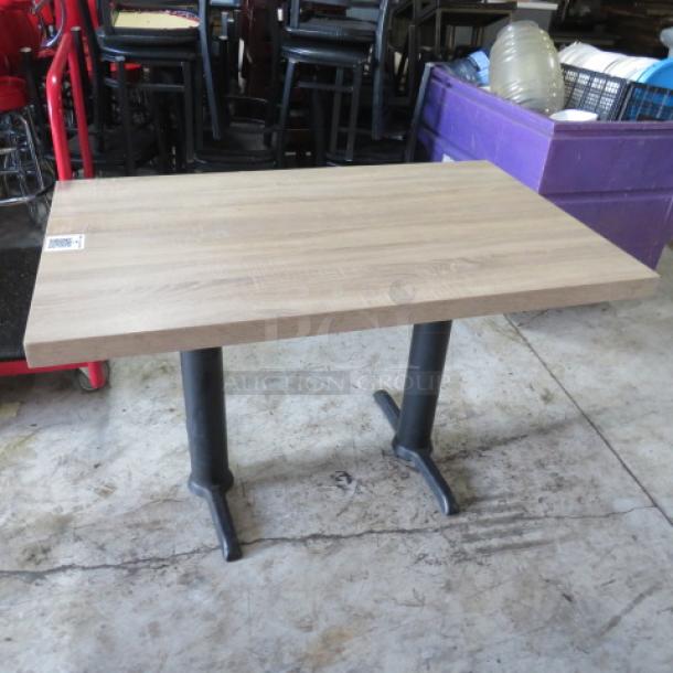 Brown tabletop with dual pedestal bases, 48x30x30 inches, in good condition. No visible markings or labels.