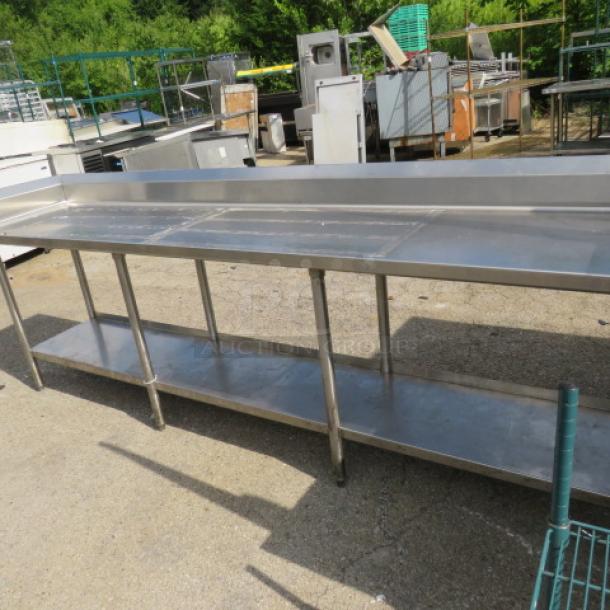 Stainless steel table with left side splash and back splash, under shelf, 112x24x40 inches. Good condition.
