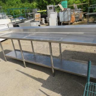 Stainless steel table with left side splash and back splash, under shelf, 112x24x40 inches. Good condition.