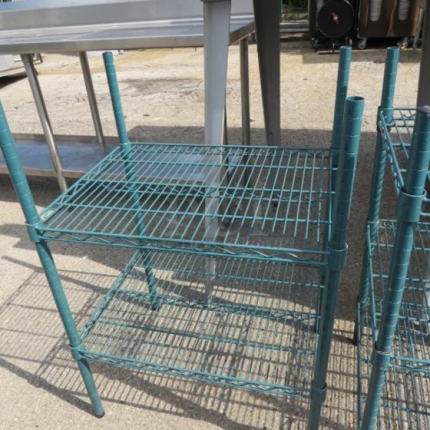 Green Metro shelf with two tiers, measuring 24x18x35 inches. Made from durable metal, good condition.