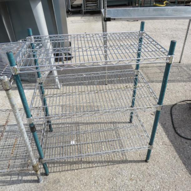Green Metro shelf unit with three wire shelves, measuring 30x18x35 inches. Sturdy condition, suitable for storage.