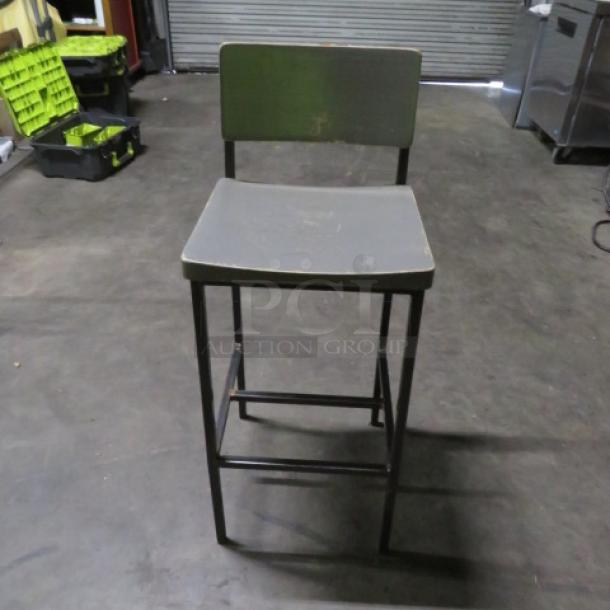Metal bar height chair with gray wooden seat and back, footrest, and metal frame. Used condition. Model 2XBID.