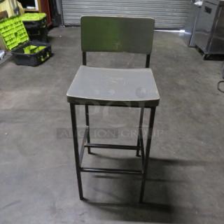 Metal bar height chair with gray wooden seat and back, footrest, and metal frame. Used condition. Model 2XBID.