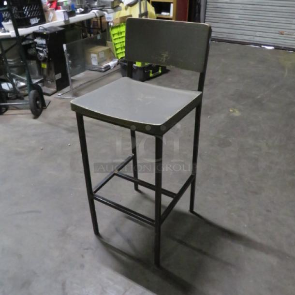Metal bar height chair with gray wooden seat and back, footrest, sturdy condition. Ideal for industrial settings.