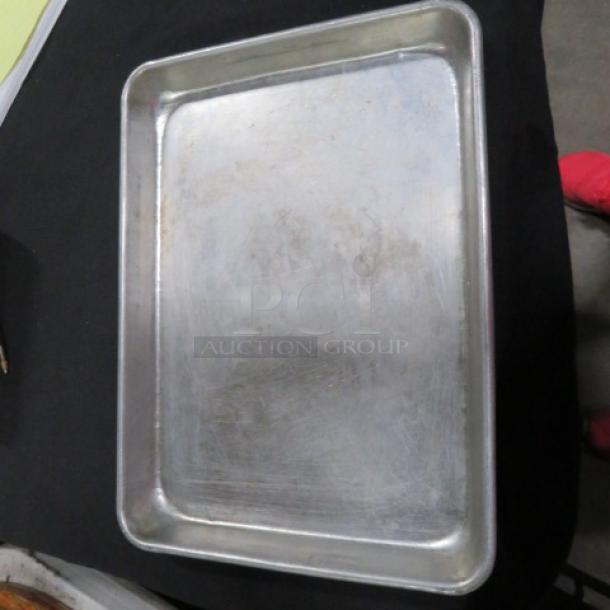 One lot of 50 aluminum sheet pans, size 13x9.5 inches, used with surface scratches, ideal for baking needs.