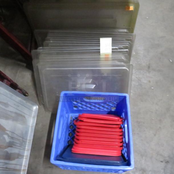 Assorted food storage lids in large lot; includes red and transparent lids in various shapes and sizes, used condition.