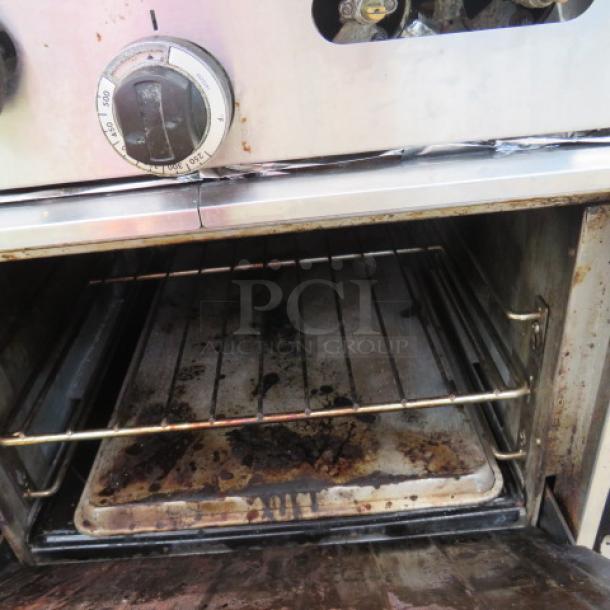 Sunfire 4 Burner Natural Gas Range, Model X24-4L, with oven rack and stainless steel overshelf. Shows signs of use.