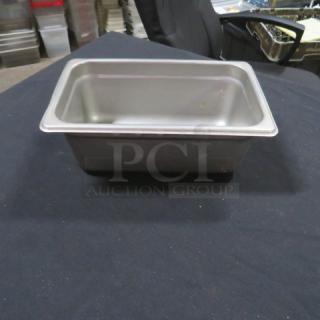 1/4 size 4-inch deep stainless steel hotel pan, used, minor wear visible, ideal for food storage and service.