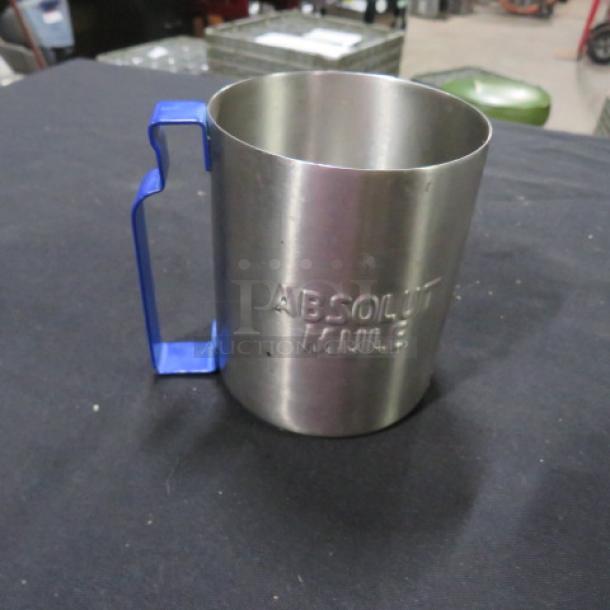 Stainless steel mug with "Absolute Mule" embossed, featuring a blue handle; appears in excellent condition.