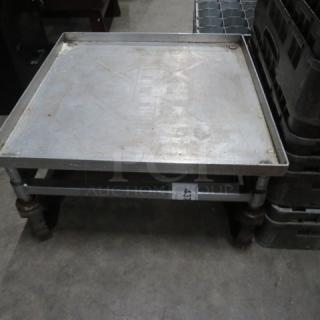 Metal dish rack dolly with wheels, used, sturdy build, signs of wear, ID tag marked "43" visible on frame.