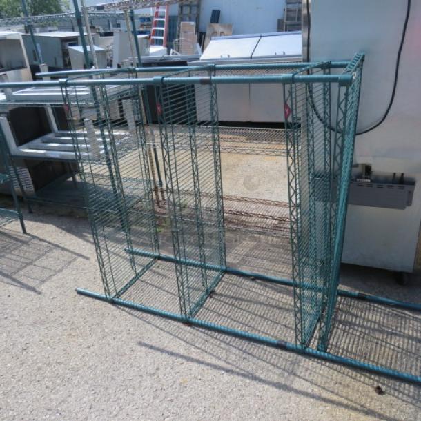 Green Metro shelf unit with four shelves, partially assembled. Dimensions: 48x21x75 inches. Steel construction, outdoor setting.