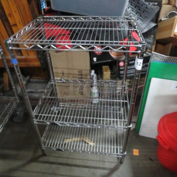 Metro steel shelf unit with three wire shelves, 24"x18"x36", on casters, good condition, ideal for storage or display.