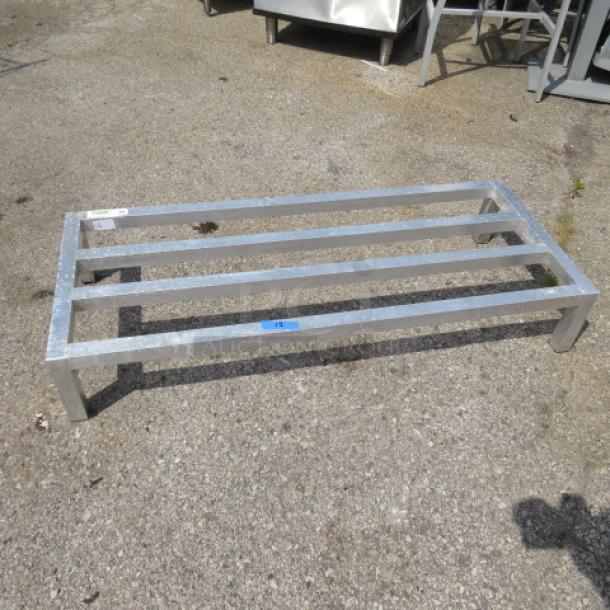 Aluminum dunnage rack, 48x20x8 inches, sturdy frame with five slats, suitable for storage, shows minor outdoor use.