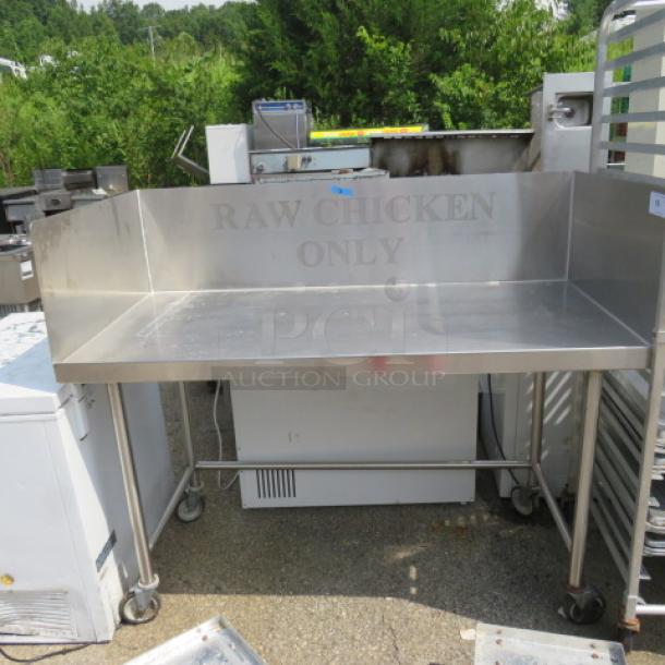 Stainless steel table with right/left backsplash, on casters, 60x30x51 inches, marked "RAW CHICKEN ONLY", good condition.