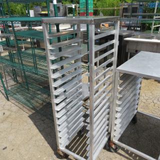 Aluminum speed rack on casters, 15.5x8x54 inches. Features multiple shelves for bakery use. Slight wear visible.