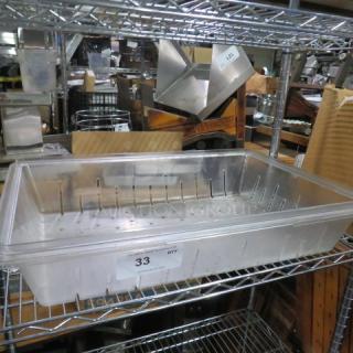 Perforated food storage container, 25x18x5 inches, clear plastic, rectangular, used, labeled with number "33", on metal shelf.