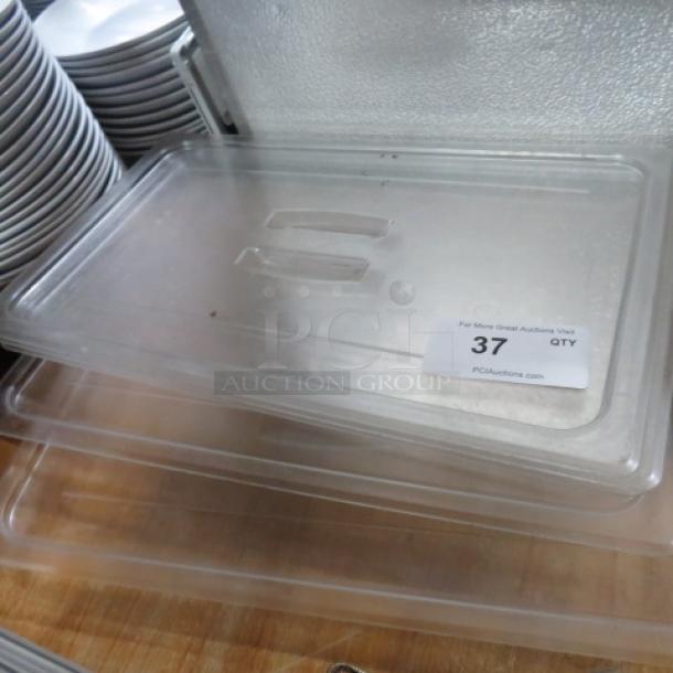 Clear full-size food storage lid, model 4XBID, in good condition. Label indicates quantity 37, auction company details visible.