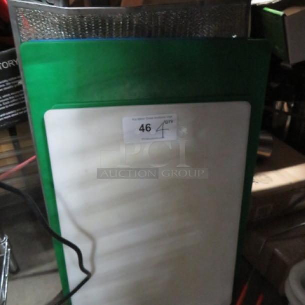 Assorted cutting boards, green and white, lightly used; label indicating "46" and "4XBID," stored vertically.