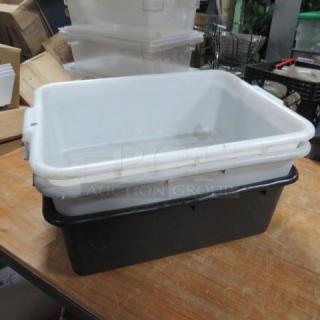 Three assorted bussing tubs stacked; two white, one black. Used condition. Ideal for restaurant or catering services.