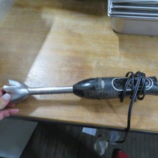 Braun stick blender, black handle, metal shaft, used condition, visible Braun logo, power cord wrapped around.