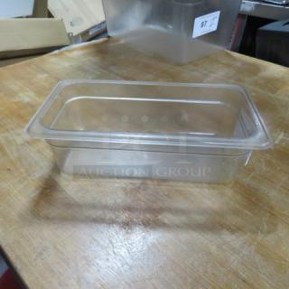 Clear 1/3 size food storage container, 4 inches deep, on wooden surface. Slightly used condition. No visible markings.