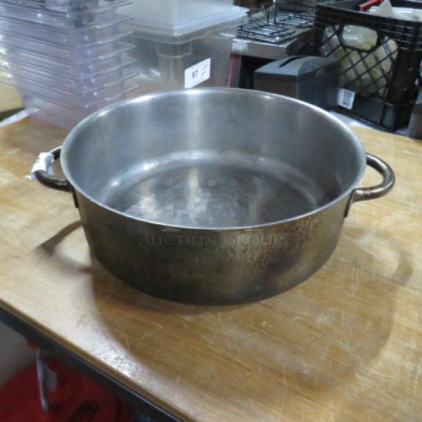 Stainless steel stock pot, 16.5" diameter, 6" height, used condition, with sturdy side handles.