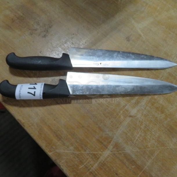 Assorted chef knives with black handles, stainless steel blades. Visible label on one handle reads "117." Good condition.
