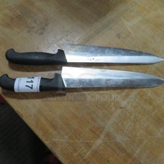 Assorted chef knives with black handles, stainless steel blades. Visible label on one handle reads "117." Good condition.