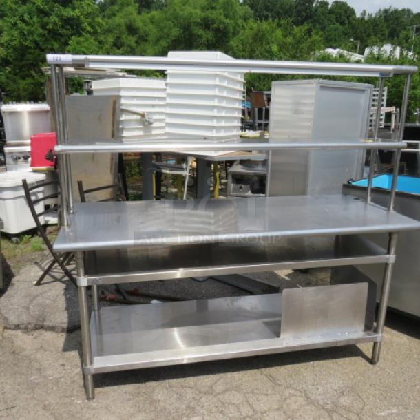 Advance Tabco stainless steel table with 2 under shelves, 2 over shelves, and a 60-inch San Jamar ticket rail. Size: 72x30x67 inches.
