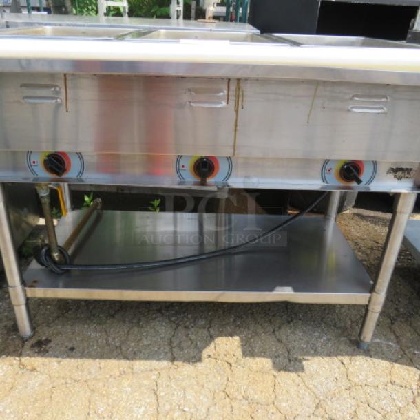 APW Wyott 3-well steam table with stainless steel undershelf and cutting board, size 46x30x34.5 inches, used condition.