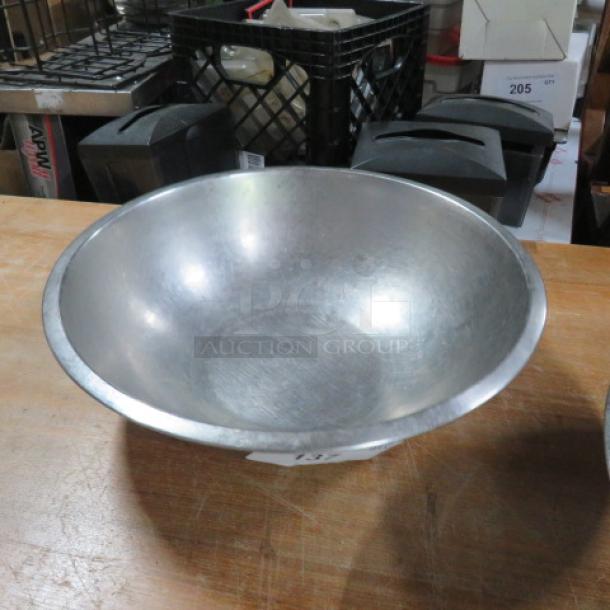 16.5-inch stainless steel mixing bowl. Durable with a smooth finish. Slightly worn but in good condition, ideal for kitchen use.
