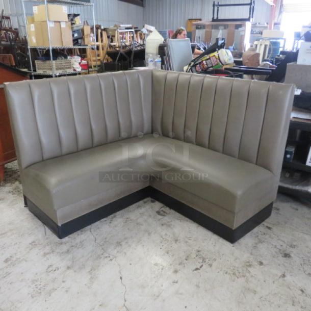 Corner booth with gray cushions, 58x27x42 inches, in good condition. Features vertical stitching and black base.