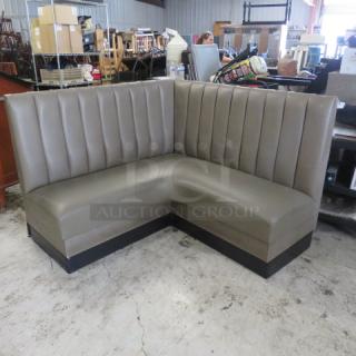 Corner booth with gray cushions, 58x27x42 inches, in good condition. Features vertical stitching and black base.