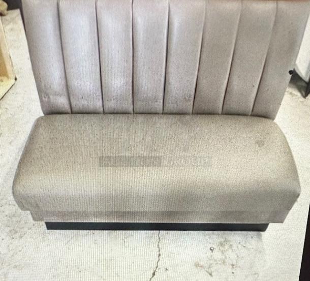 Single-sided booth with grey cushioned seat and back. Vertical stitching on backrest. Used condition, no visible tags.