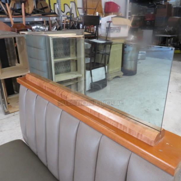 Double-sided booth with wooden top rail, glass divider, and grey cushioned seat and back, 50x50x52, in good condition.