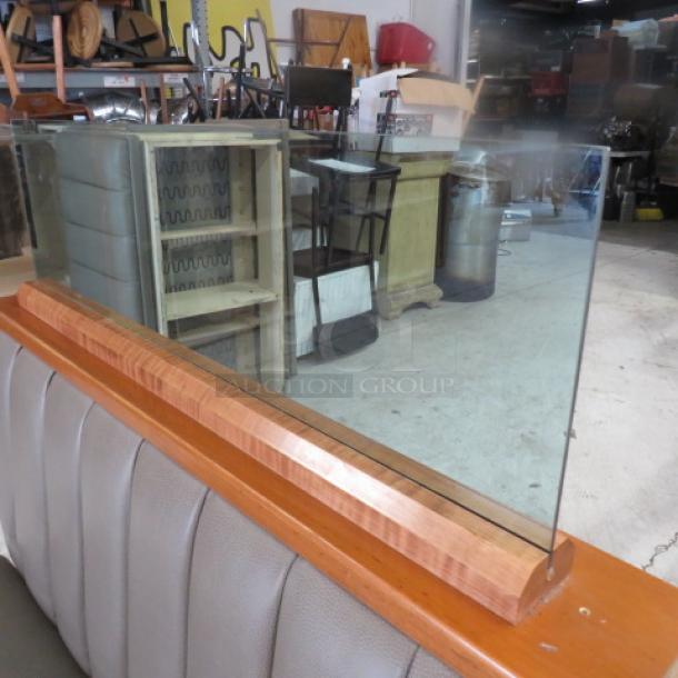 Double-sided booth with wooden top rail, glass divider, and grey cushioned seat and back, dimensions 50x50x52 inches.