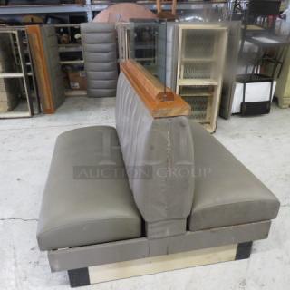 Double-sided booth with grey cushioned seat and back, wooden top rail, glass divider, measuring 50x50x52, used condition.