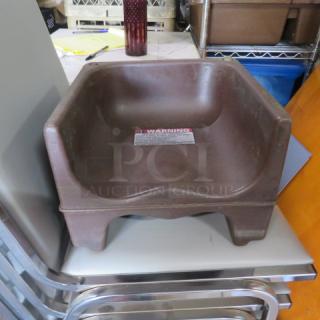 Cambro booster seat, model 200BC, brown, plastic material, sturdy design, warning label visible, in used condition.